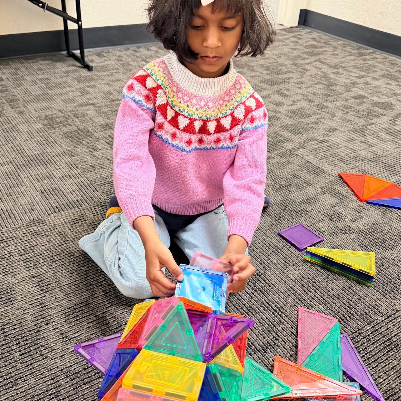 A student experimenting with colorful magnetic building tiles